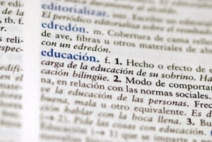 Spanish dictionary definition of the word education, representing a student working through a Spanish class vocabulary lesson